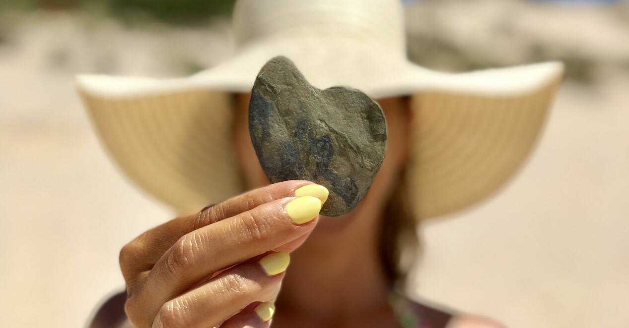 kvinna på stranden med citrongult nagellack